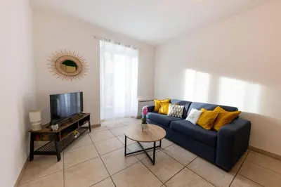 a living room with a blue couch and a tv at Joli cocon à 3 min à pied de la mer in Nice