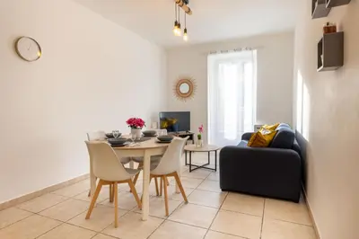 a living room with a table and a couch at Joli cocon à 3 min à pied de la mer in Nice
