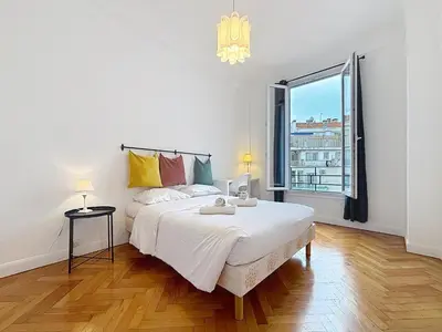 a white bedroom with a large bed and a window at Nice Carlone Appart 6 pers, Clim, proche mer, transports in Nice
