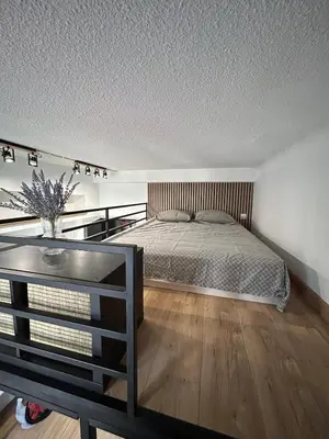 a bedroom with a bed and a wooden floor at Studio en plein cœur de Nice in Nice