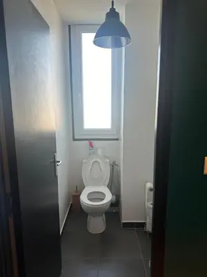a small bathroom with a toilet with a window at Cocon Azur avec vue panoramique sur mer - 4 chambres in Nice