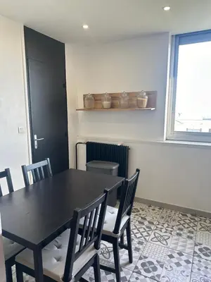 a dining room with a black table and chairs at Cocon Azur avec vue panoramique sur mer - 4 chambres in Nice