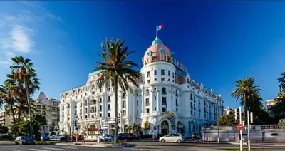 a white building with a flag on top of it at Chic Flat Near the Beach in Nice