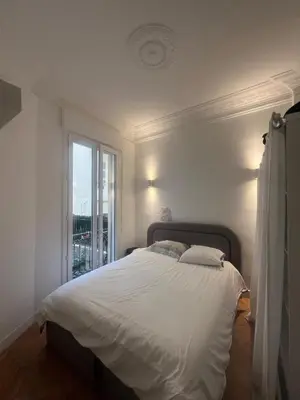 a white bed in a bedroom with a window at Chic Flat Near the Beach in Nice