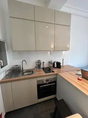a kitchen with white cabinets and a sink at Chic Flat Near the Beach in Nice