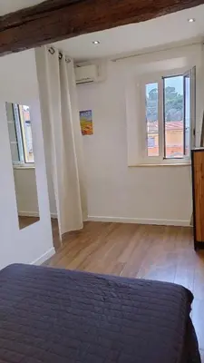 a bedroom with a bed and two windows at cozy apartment port of Nice in Nice
