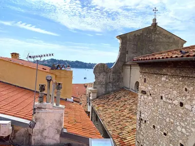 a view of the roofs of buildings and a lake at PERCHOIR AP4443 By Riviera Holiday Homes in Villefranche-sur-Mer