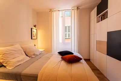 a bedroom with a large bed with a window at PORT LYMPIA AP4429 By Riviera Holiday Homes in Nice