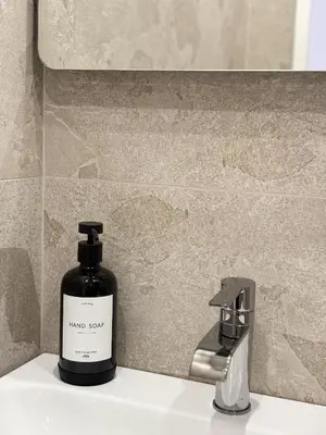 a bottle of soap sitting on a sink next to a faucet at Appartement de luxe climatisé, parking & 2 balcons in Villefranche-sur-Mer