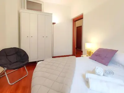 a bedroom with a large white bed and a chair at Grimaldi Centrale 3 Pers WiFi AC in Nice