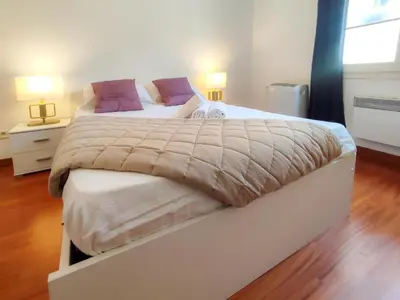a large bed in a bedroom with two lamps at Grimaldi Centrale 3 Pers WiFi AC in Nice