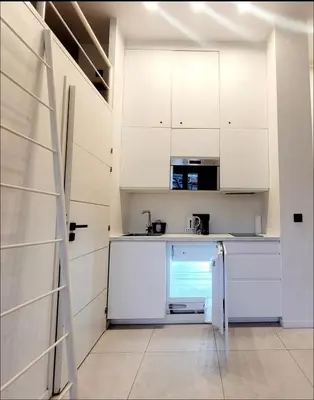 a kitchen with white cabinets and a refrigerator at Centre-ville Proche gare in Nice