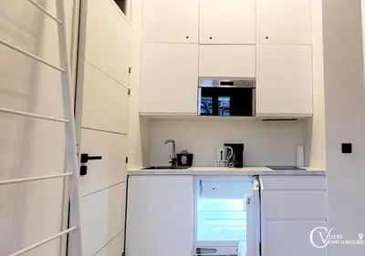 a kitchen with white cabinets and a microwave at Centre-ville Proche gare in Nice