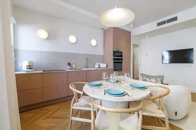 a kitchen and dining room with a table and chairs at Maison Galbani Architect-designed apartment in Nice