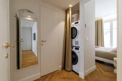 a bathroom with a washer and dryer and a mirror at Maison Galbani Architect-designed apartment in Nice