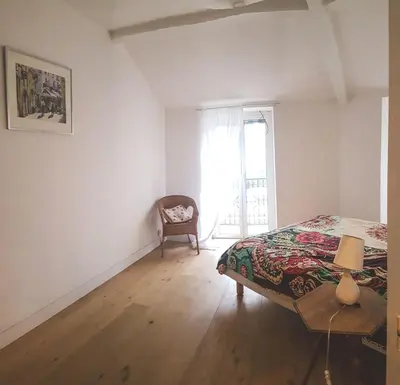 a bedroom with a bed and a chair and a window at Top floor appartement - central in Nice