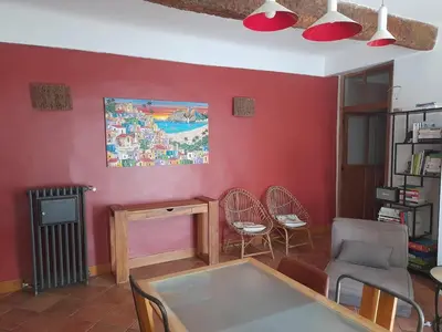 a living room with red walls and a table and chairs at Village house surrounded by greenery in La Gaude