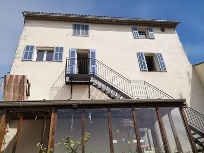 a building with glass windows and a balcony at Village house surrounded by greenery in La Gaude