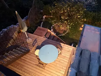 an overhead view of a wooden deck with a table at Village house surrounded by greenery in La Gaude