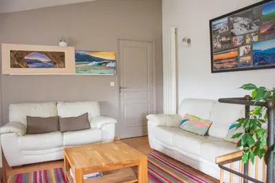 a living room with two white couches and a table at Village house surrounded by greenery in La Gaude
