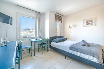 a bedroom with a bed and a desk and a window at Studio hypercentre gare in Nice