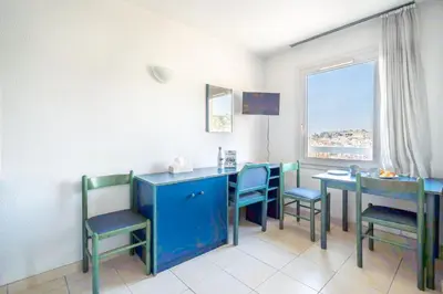 a dining room with blue chairs and a table and a window at Studio hypercentre gare in Nice