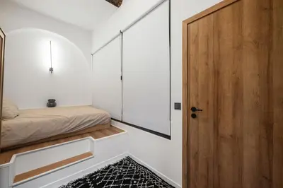 a small bedroom with a bed and a wooden door at Beautiful apartment, old nice in Nice