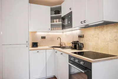 a kitchen with white cabinets and a stove top oven at Beautiful apartment, old nice in Nice