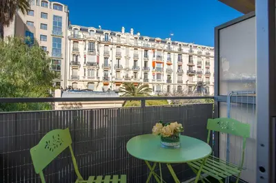 a table and chairs on a balcony with a view of a building at Azur Central Flat in Nice