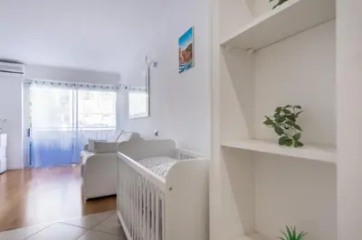 a white living room with a staircase and a couch at Azur Central Flat in Nice