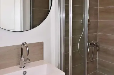 a bathroom with a shower with a sink and a mirror at Barla 1 - a cosy one bedroom apartment in Nice in Nice