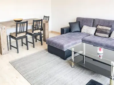 a living room with a couch and a table and chairs at Lympia - one bedroom apartment near the port in Nice