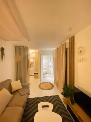 a living room with a couch and a bathroom at Studio Boho Chic - Proche de la mer in Nice