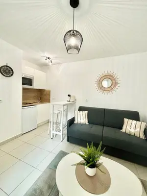 a living room with a couch and a table at Nid douillet rénové et tramway à 1 min in Nice