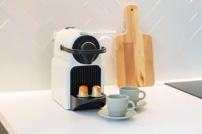 a coffee maker and two cups on a counter at Nice Renting - 8BONAPARTE - Architect Loft Luxury 4 Bedrooms View Place du Pin in Nice