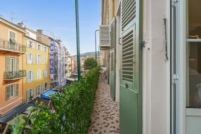 a narrow alley with a green door on a building at Nice Renting - 8BONAPARTE - Architect Loft Luxury 4 Bedrooms View Place du Pin in Nice