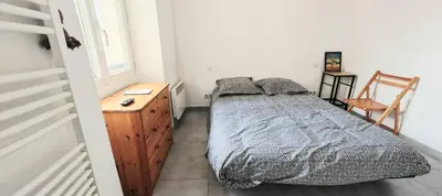 a bedroom with a bed and a wooden dresser at Appartement au coeur de la ville in Nice