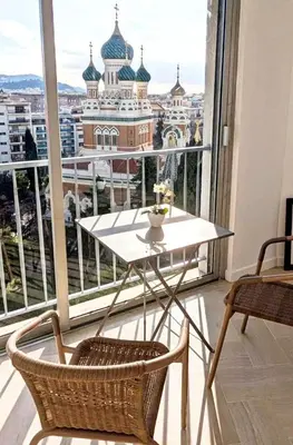 a table and chairs in front of a large window at 3P 72m2 Climatisé Vue exceptionnelle Cathédrale St Nicolas et Mer in Nice