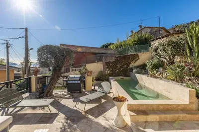 a backyard with a swimming pool and patio furniture at Villa Margot ' Exceptional Place in Villefranche-sur-Mer