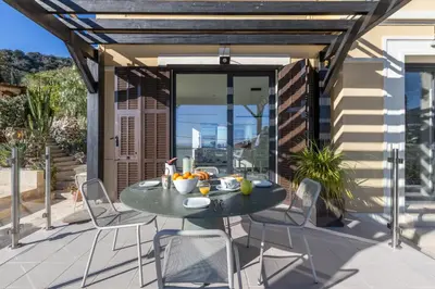 a patio with a table and chairs on a balcony at Villa Margot ' Exceptional Place in Villefranche-sur-Mer