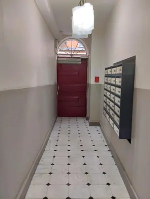 a hallway with a red door and a tiled floor at Studio au cœur du vieux Nice in Nice