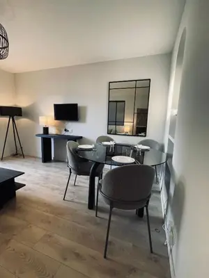 a living room with a table and chairs and a television at Appartement avec Terrasse - Palais Historique à Nice in Nice