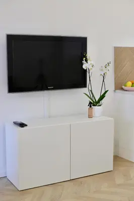 a white entertainment center with a tv on a white wall at Magnifique appartement proche mer in Nice