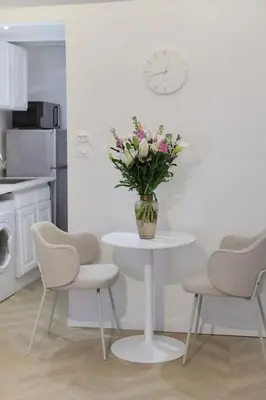 a vase of flowers on a white table in a kitchen at Superbe appartement & proche mer in Nice