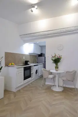 a kitchen with white cabinets and a table and chairs at Superbe appartement & proche mer in Nice