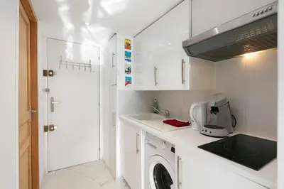 a white kitchen with a washer and dryer on a counter at Studio Jaune FSHH in Nice
