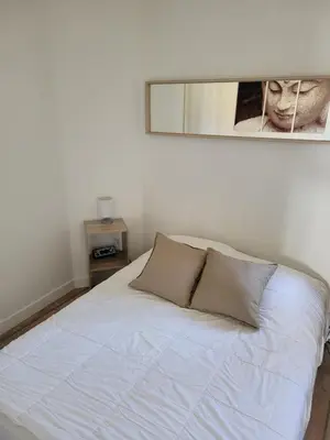 a white bed in a room with a picture on the wall at Bas de villa plus piscine Vue époustouflante in Villefranche-sur-Mer