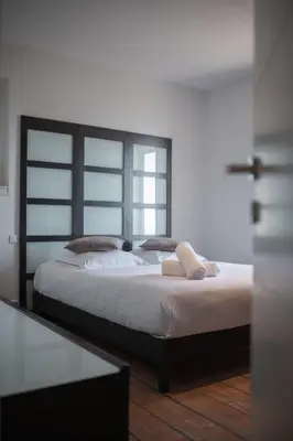 a bedroom with a large bed with white sheets and pillows at Bas de villa plus piscine Vue époustouflante in Villefranche-sur-Mer