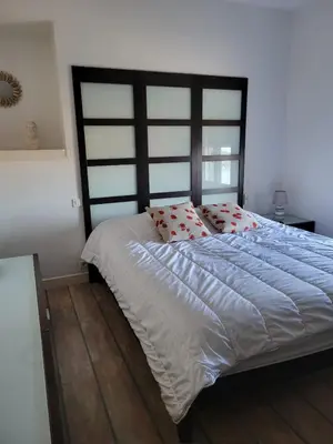 a bedroom with a large bed with red pillows at Bas de villa plus piscine Vue époustouflante in Villefranche-sur-Mer