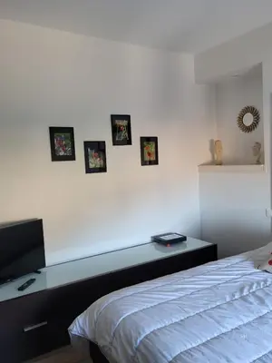 a bedroom with a bed and pictures on the wall at Bas de villa plus piscine Vue époustouflante in Villefranche-sur-Mer